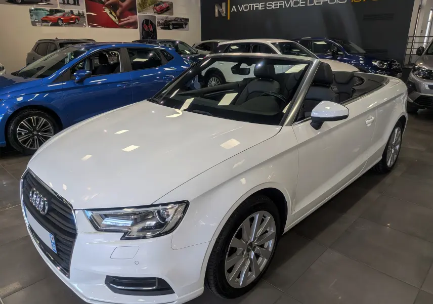 Audi A3 Cabriolet blanc vue 3/4 avant droit, capote ouverte, intérieur noir visible en concession.
