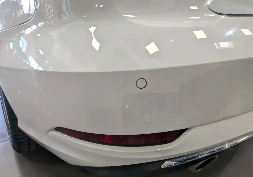 Gros plan sur l'angle arrière droit blanc de l'Audi A3 Cabriolet 2017, avec feu arrière et capteur de recul visibles.