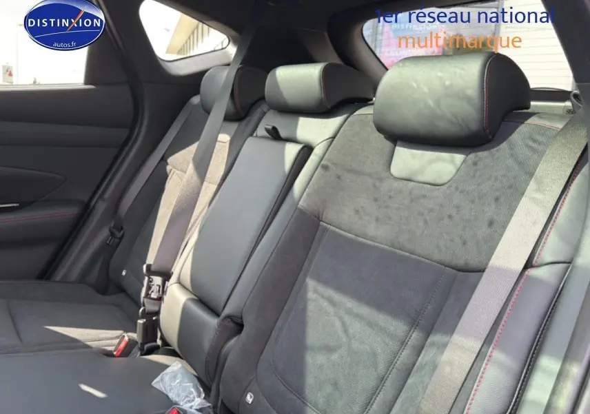 Vue intérieure sur la banquette arrière en cuir noir et alcantara avec surpiqûres rouges du Hyundai Tucson 2026.