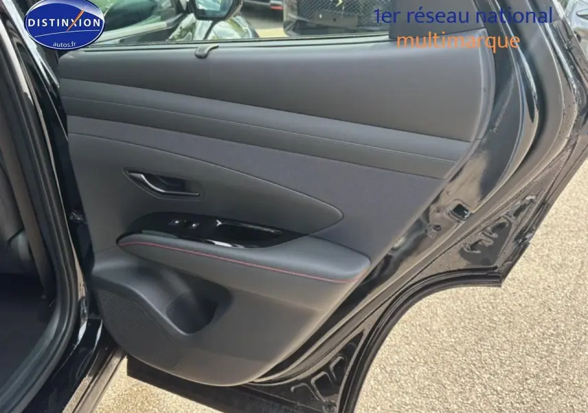 Vue intérieure de la porte arrière droite noire du Hyundai Tucson 2026 avec garniture cuir et surpiqûres rouges.
