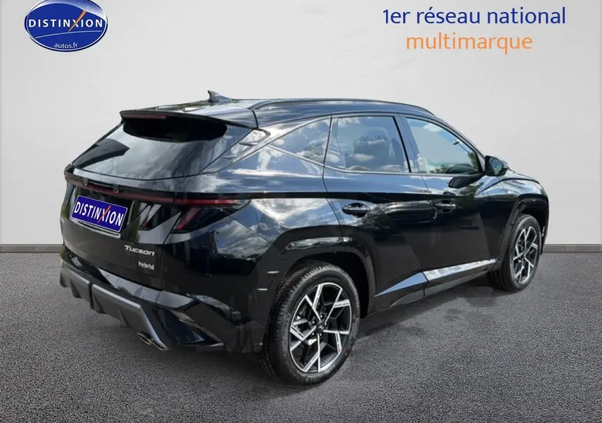 Vue 3/4 arrière droite du Hyundai Tucson noir hybride avec jantes alu et feux arrière LED fins.