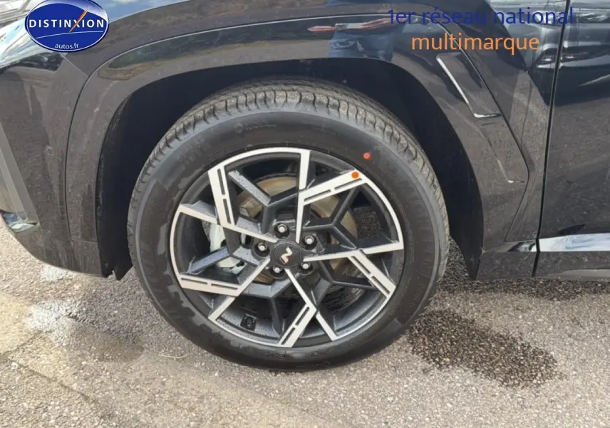 Gros plan sur la roue avant droite noire du Hyundai Tucson 2026 avec jante alu au design géométrique.
