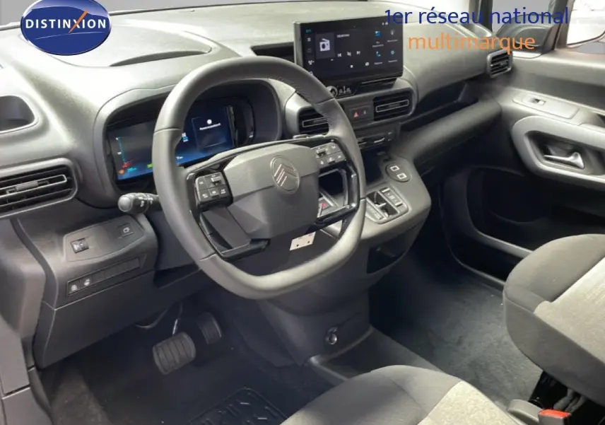 Vue intérieure centrée sur le volant multifonction et tableau de bord numérique du Citroën Berlingo 2026, finition tissu noir.