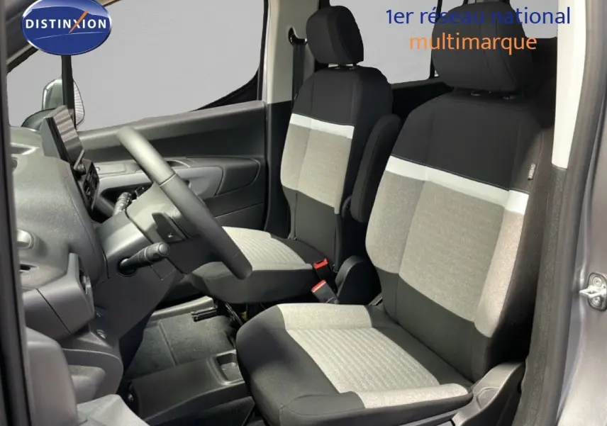 Vue intérieure côté conducteur du Citroën Berlingo gris Artense, sièges tissu bi-ton gris et noir avec volant multifonction.