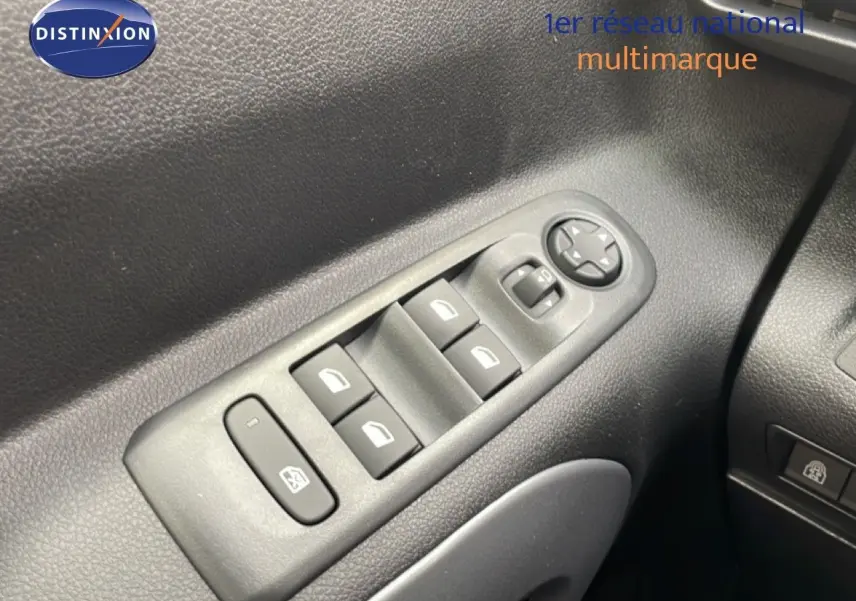 Gros plan sur les commandes des vitres électriques côté conducteur du Citroën Berlingo gris Artense 2026.
