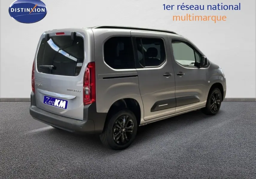 Vue 3/4 arrière droite d'un Citroën Berlingo gris Artense métallisé avec vitres teintées et jantes noires.