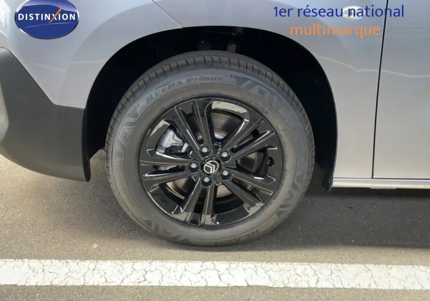 Gros plan sur la roue avant gauche noire brillante du Citroën Berlingo gris Artense Metal 2026.