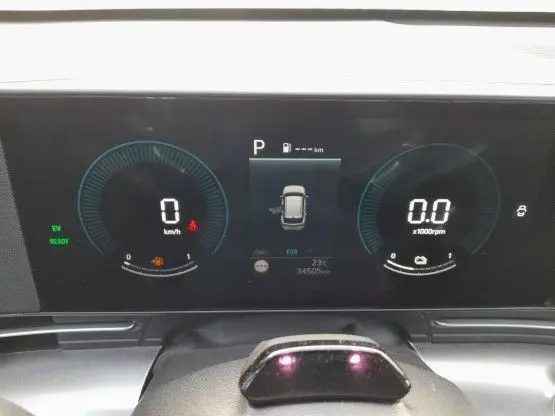 Tableau de bord numérique du Hyundai Kona 2024 en vue frontale, affichant vitesse, régime moteur et état hybride.