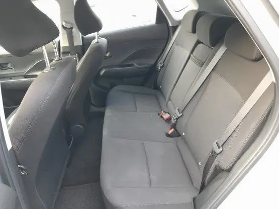 Vue intérieure côté droit des sièges arrière en tissu noir du Hyundai Kona 2024 hybride, avec ceintures et appuie-têtes visibles.