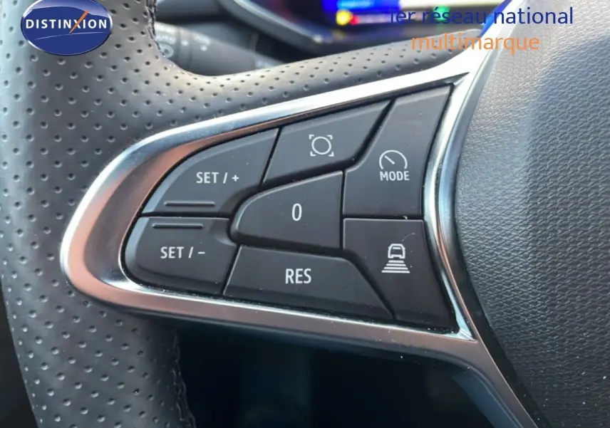 Gros plan sur les commandes de régulateur au volant perforé d’une Renault Symbioz gris cassiopée métal, version hybride 2025.