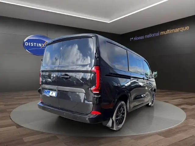 Vue 3/4 arrière droite du Volkswagen Transporter ProCab noir métallisé avec jantes alliage noires et feux arrière LED signature distinctive.