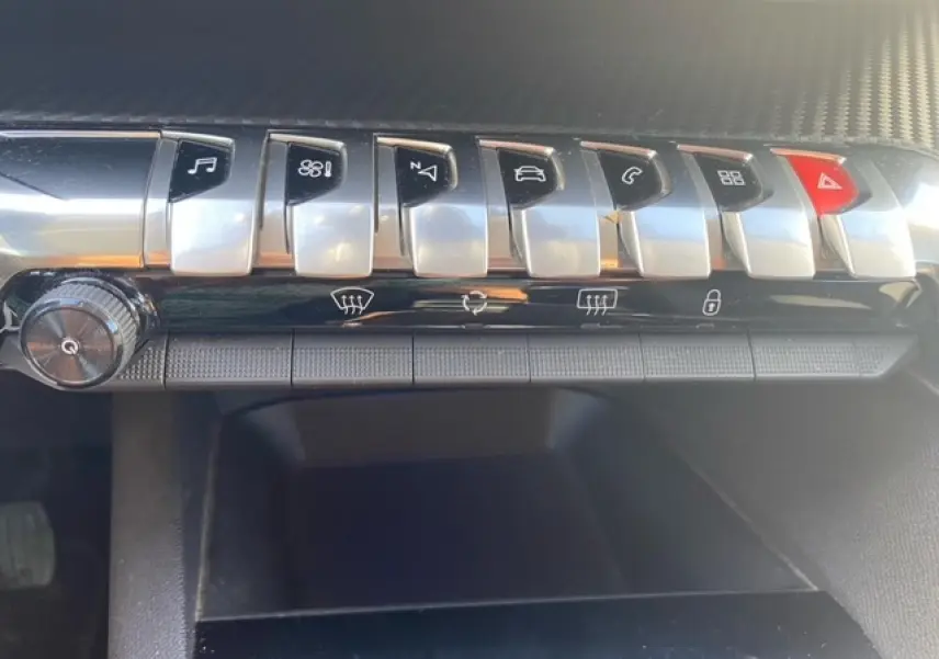 Gros plan sur la rangée de boutons argentés du tableau de bord du Peugeot 3008 beige clair, version 2018.