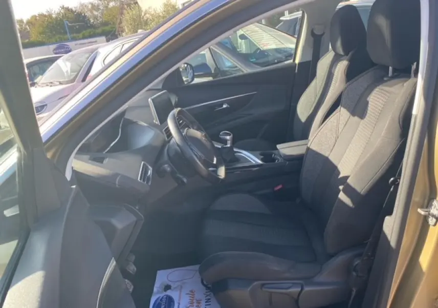 Vue intérieure côté conducteur du Peugeot 3008 beige clair, montrant les sièges tissu et le volant compact multifonctions.