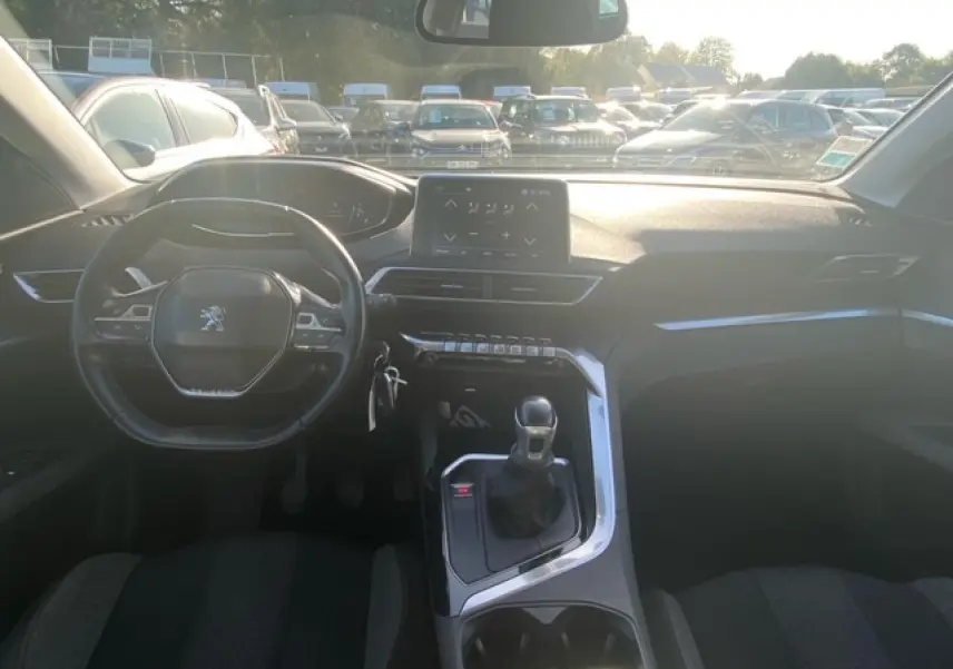 Vue intérieure avant du Peugeot 3008 beige clair, mettant en valeur le volant compact, la boîte manuelle et l'écran tactile central.