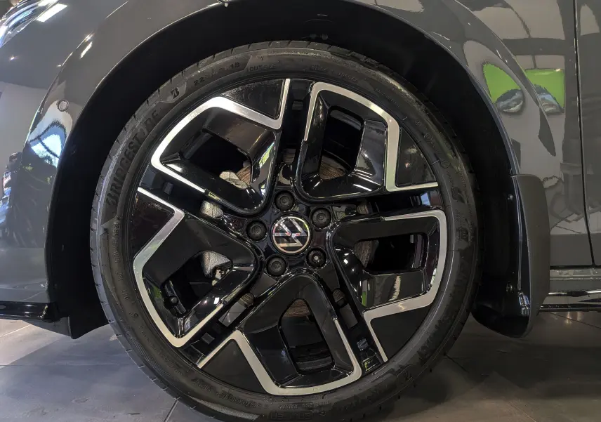 Gros plan sur la jante biton noir et argent de la Volkswagen Golf VIII gris Urano, mettant en valeur son design moderne.