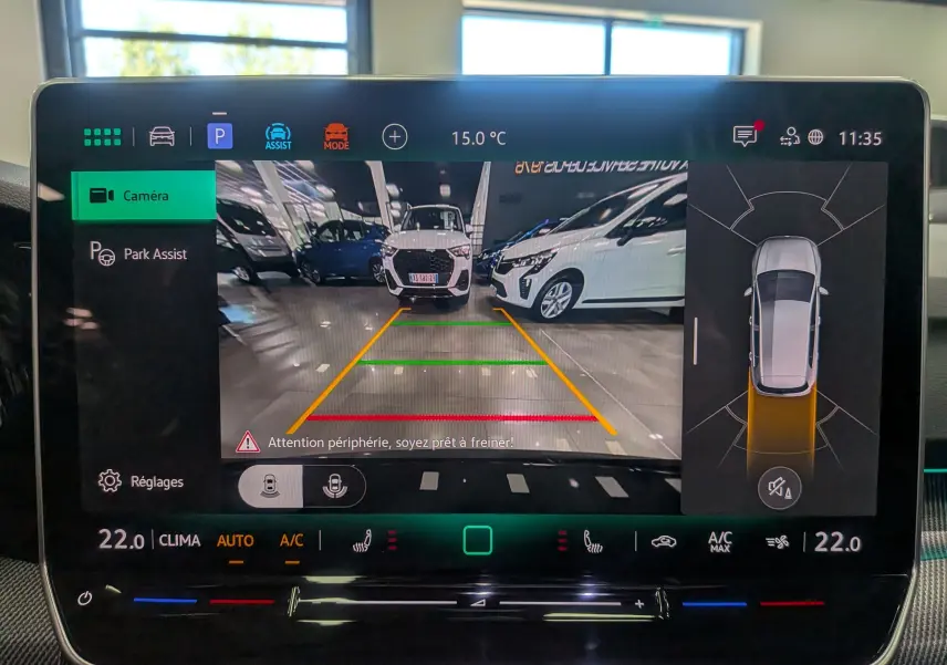 Écran multimédia de la Volkswagen Golf VIII gris Urano montrant la caméra de recul et l'assistance au stationnement.