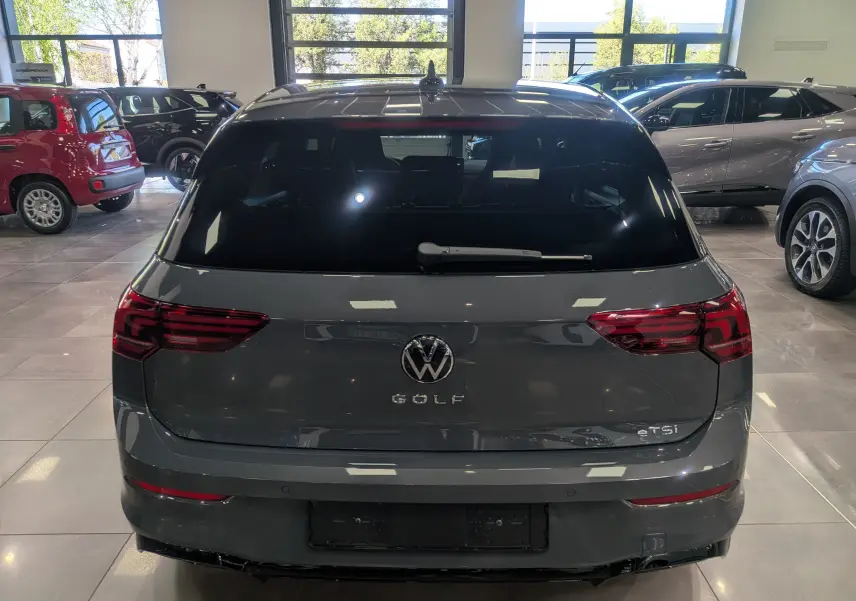 Vue arrière d'une Volkswagen Golf VIII gris Urano en finition R-Line Edition, avec feux arrière LED et logo central visible.
