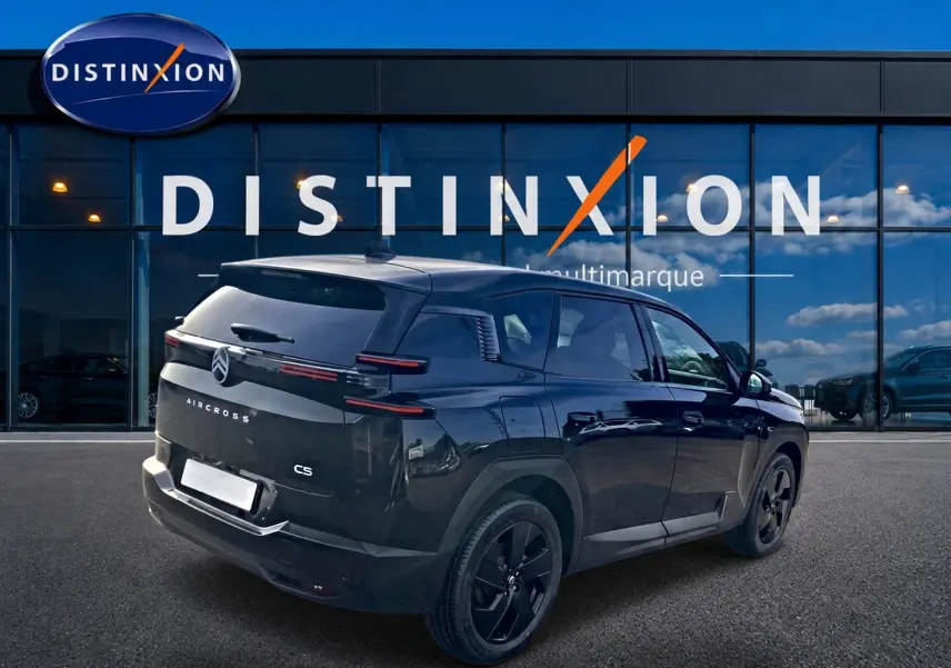 Vue 3/4 arrière droite du Citroën C5 Aircross noir avec jantes noires devant une vitrine Distinxion.