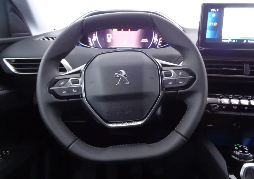 Volant en cuir noir au design compact du Peugeot 3008 2023 avec tableau de bord numérique et commandes intégrées.