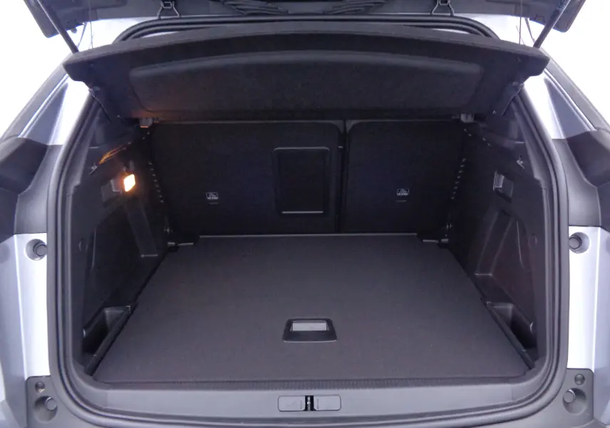 Coffre ouvert du Peugeot 3008 gris Artense Metal, montrant un espace de chargement propre et spacieux.