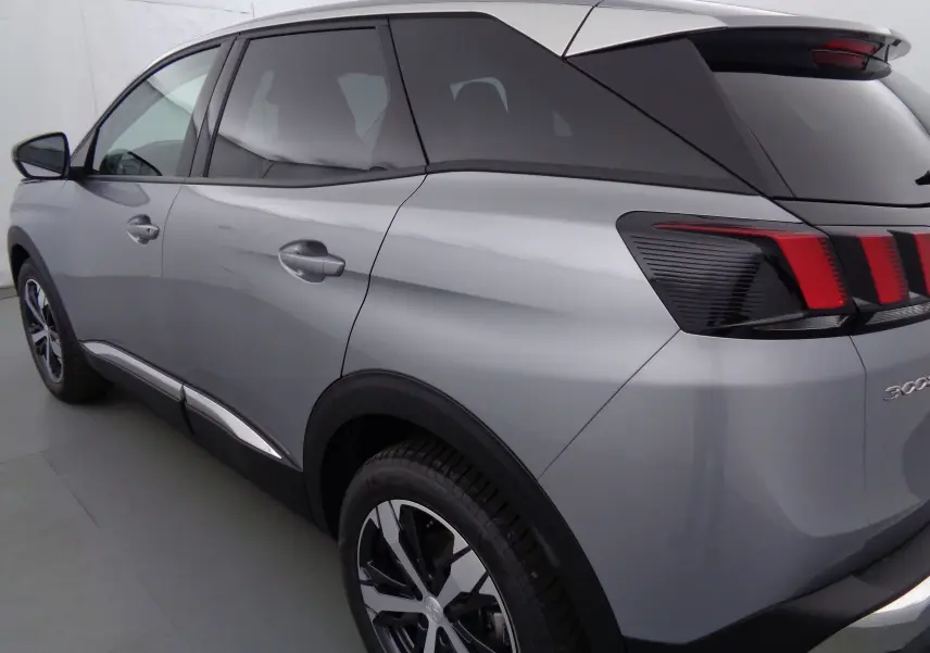 Vue 3/4 arrière côté gauche d'un Peugeot 3008 gris Artense métallisé avec feux arrière distinctifs à trois griffes rouges.
