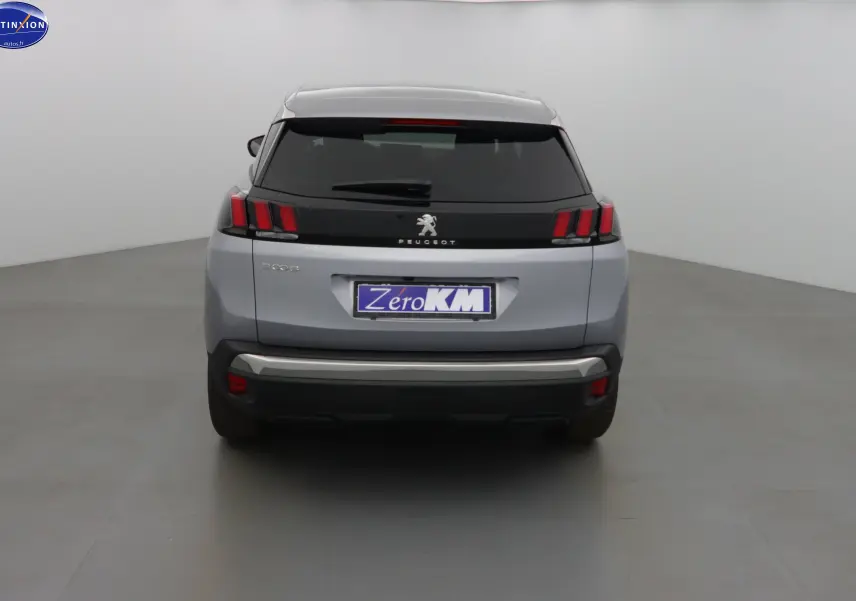 Vue arrière d'un Peugeot 3008 gris Artense métal avec feux arrière à griffes et hayon fermé dans un studio.