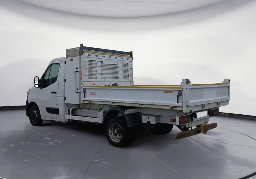 Renault Master blanc vu en 3/4 arrière droit, avec benne et coffre métallique sur plateau ouvert.