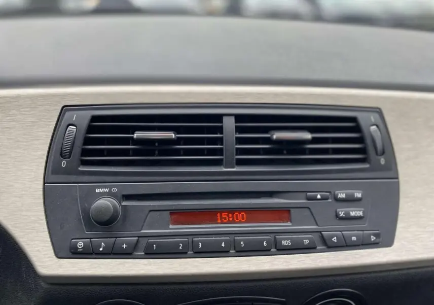 Tableau de bord de BMW Z4 Roadster gris clair 2005, vue centrée sur l'autoradio CD avec affichage digital rouge.