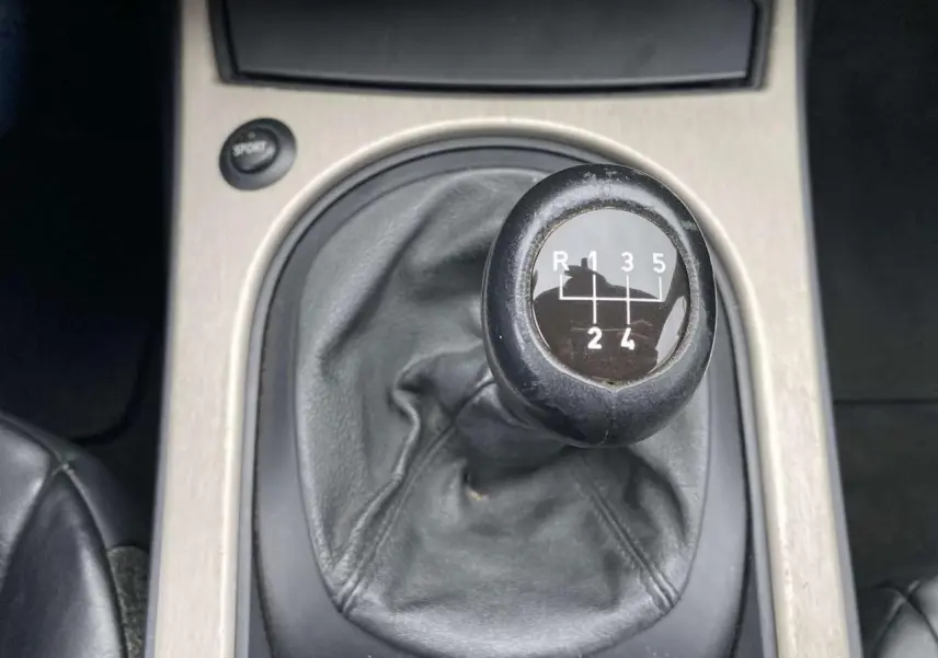 Le levier de vitesses manuel noir de la BMW Z4 Roadster 2.5i 2005 vu en gros plan sur la console centrale.