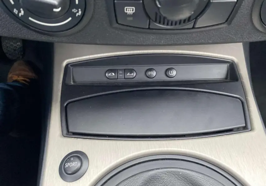 Gros plan sur la console centrale de la BMW Z4 Roadster 2005 avec bouton sport et commandes variées.