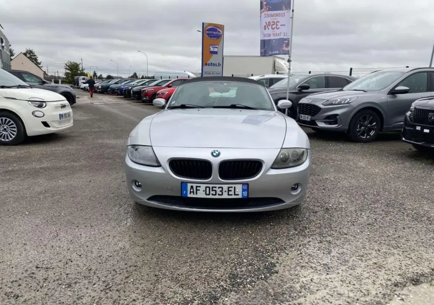 BMW Z4 Roadster gris clair vue de face, capote noire fermée, avec projecteurs antibrouillard et calandre caractéristique.