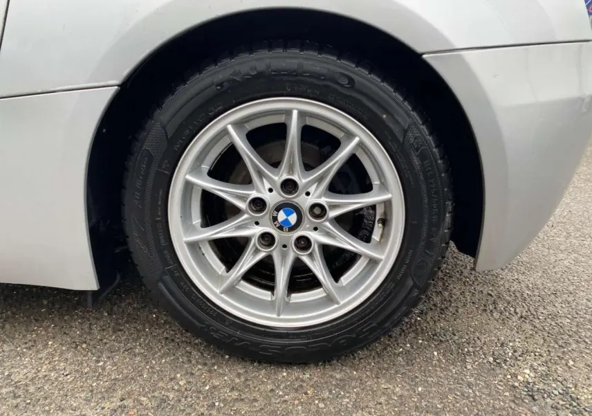 Gros plan sur la jante alliage léger 16 pouces argentée et le pneu d'une BMW Z4 Roadster gris clair, partie arrière droite visible.
