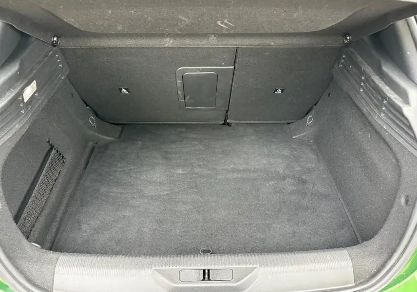 Coffre ouvert vu de face d’une Peugeot 308 2023 vert foncé, espace de chargement propre et vide.