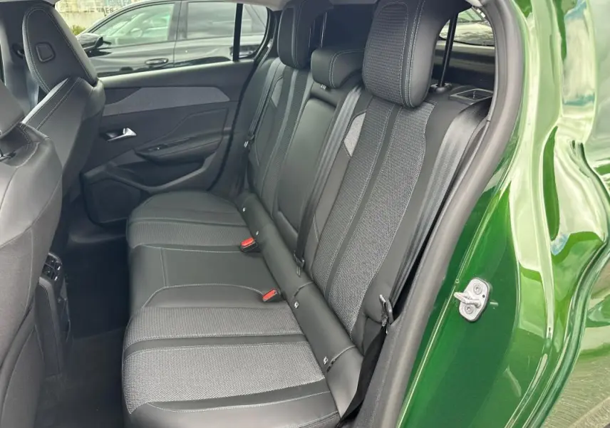 Vue intérieure côté droit sur les sièges arrière en tissu et cuir d'une Peugeot 308 vert foncé 2023.