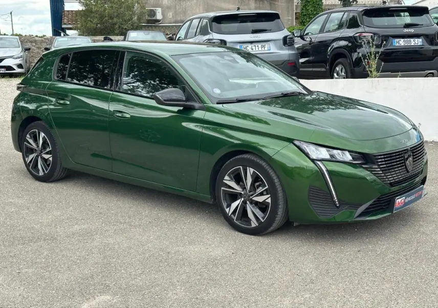 Peugeot 308 vert foncé vue 3/4 avant droit, avec jantes alliage 17 pouces et calandre distinctive noire.