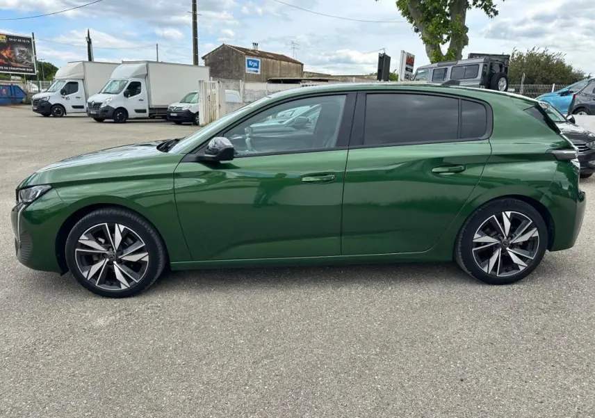 Peugeot 308 vert foncé vue de profil côté gauche, avec jantes alliage 17 pouces et vitres teintées.