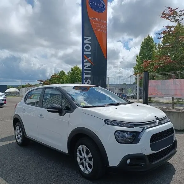 Citroën C3 Société blanche vue 3/4 avant droit, avec protections noires et jantes alliage simples.