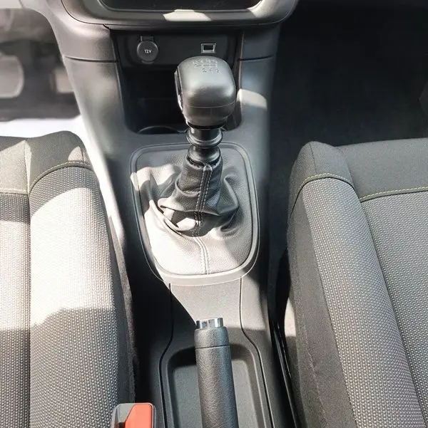 Vue plongeante sur la console centrale de la Citroën C3 Société blanche, mettant en valeur le levier de vitesses manuel et le frein à main.