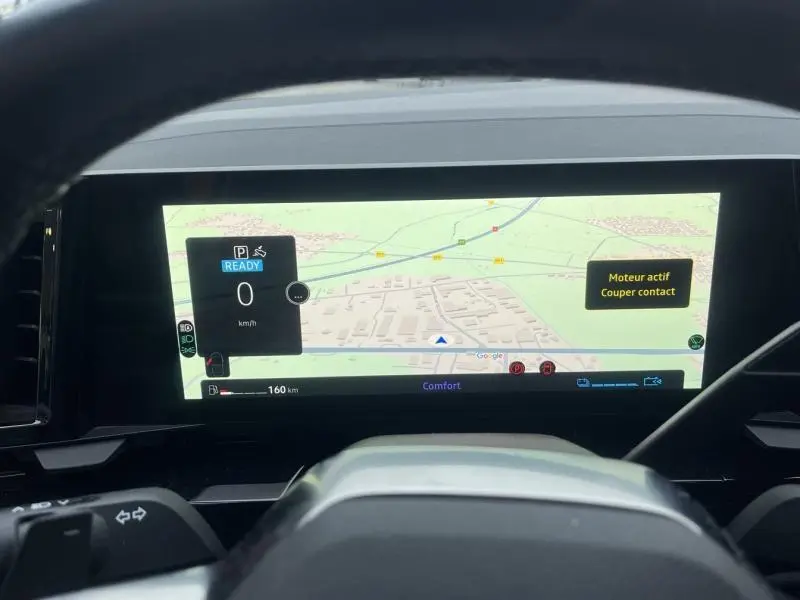 Tableau de bord numérique du Renault Austral blanc, vue depuis le volant avec navigation Google Maps affichée.