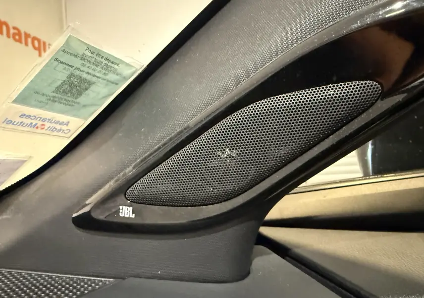 Gros plan sur l'enceinte JBL intégrée à l'intérieur côté gauche du Toyota C-HR Hybride rouge, version 2018.