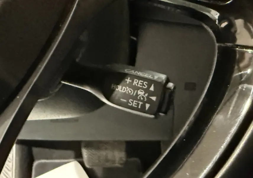 Gros plan sur la commande de régulateur de vitesse au volant du Toyota C-HR Hybride rouge, version 2018.