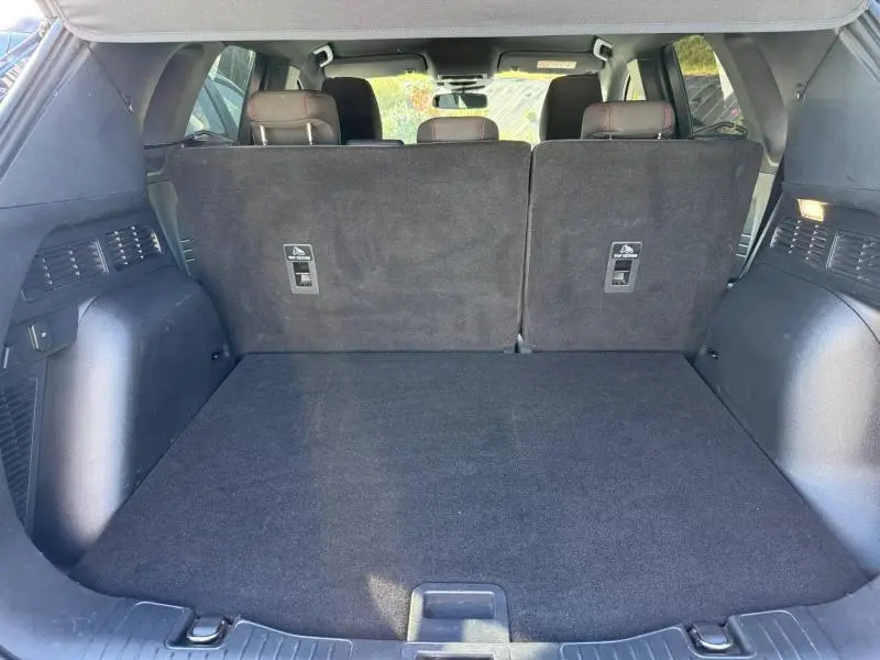Coffre spacieux du Ford Kuga 2024, vue intérieure arrière avec banquette arrière noire en position verticale.