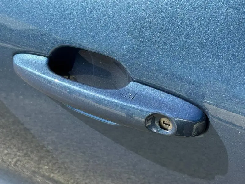 Poignée de porte avant droite bleu Abysse du Ford Kuga 2.0 EcoBlue 120ch ST-Line 2024 avec serrure visible.