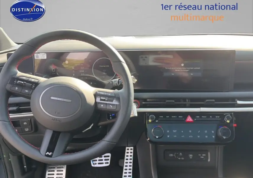 Vue intérieure du tableau de bord et volant cuir noir avec surpiqûres rouges du Hyundai Tucson 2026 gris shadow.