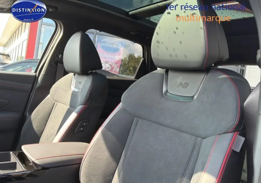 Vue intérieure des sièges avant gris alcantara avec surpiqûres rouges du Hyundai Tucson N Line 2026.