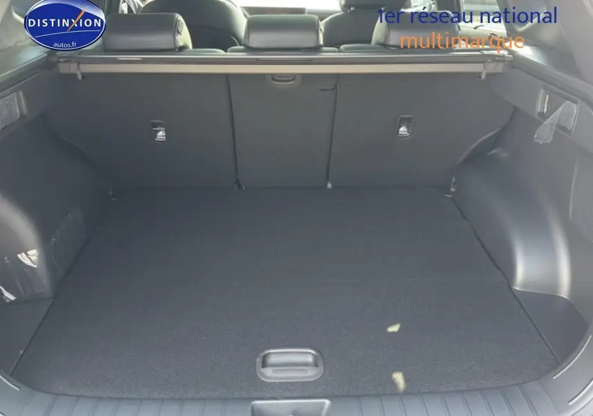 Coffre ouvert du Hyundai Tucson gris shadow, vue arrière montrant l'espace de chargement et la banquette rabattable.