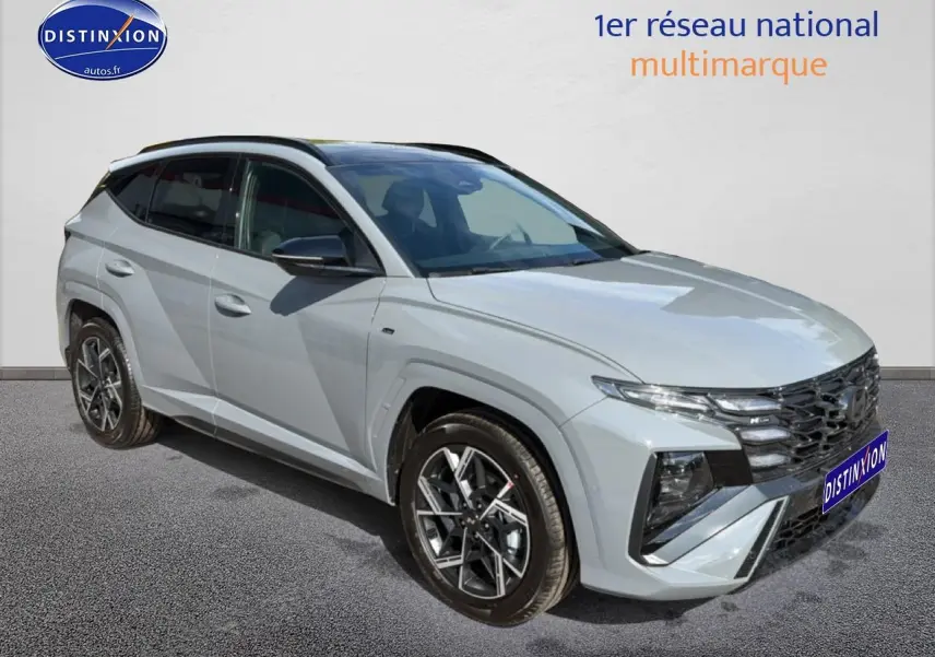 Hyundai Tucson 2026 gris shadow en 3/4 avant droit avec calandre noire et jantes alu distinctives.