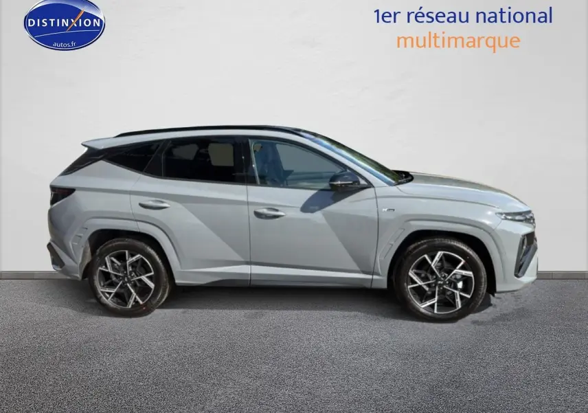 Vue de profil côté gauche du Hyundai Tucson 2026 gris shadow avec jantes alliage et toit panoramique noir.