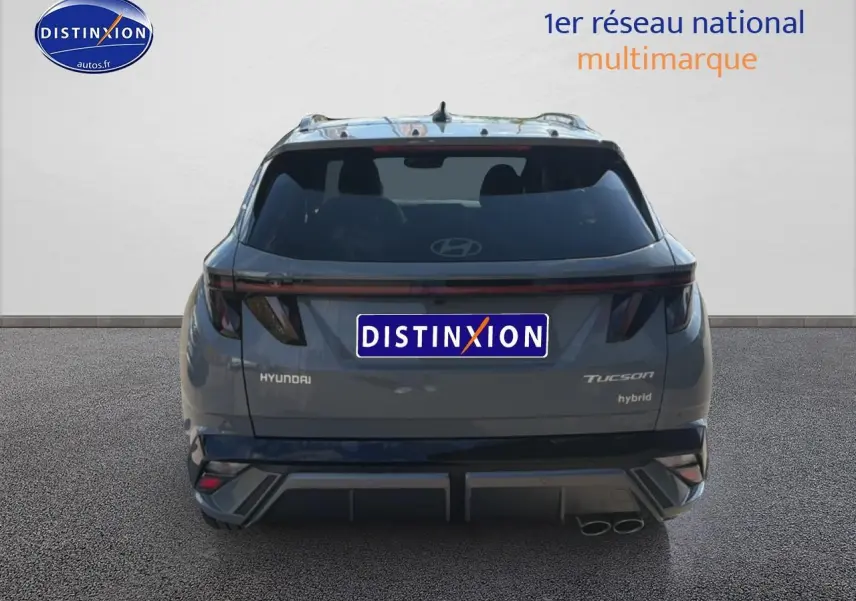 Vue arrière d'un Hyundai Tucson gris shadow hybride avec feux arrière LED et double sortie d'échappement à droite.