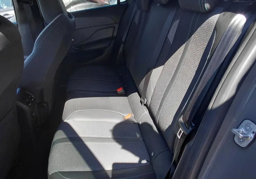 Vue intérieure côté droit des sièges arrière gris de la Peugeot 308 BlueHDi 130ch 2025 avec ceinture de sécurité visible.